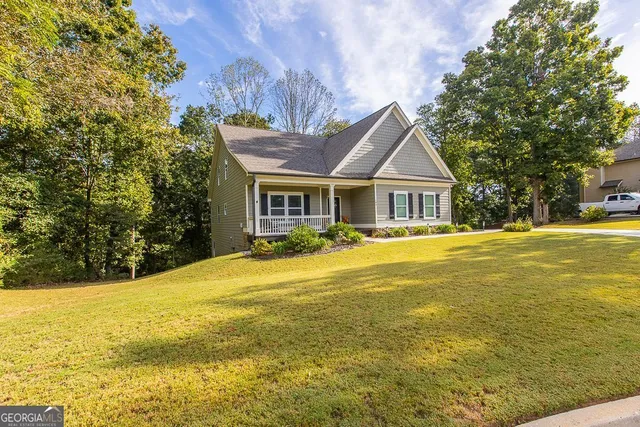 a living room with furniture floor to ceiling window and a ceiling fan