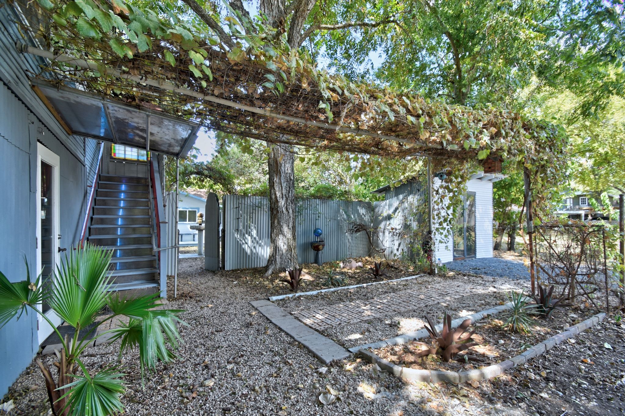 717 South Laurel Avenue Luling, TX 78648 - Photo 22 of 34 a backyard of a house with lots of trees and plants