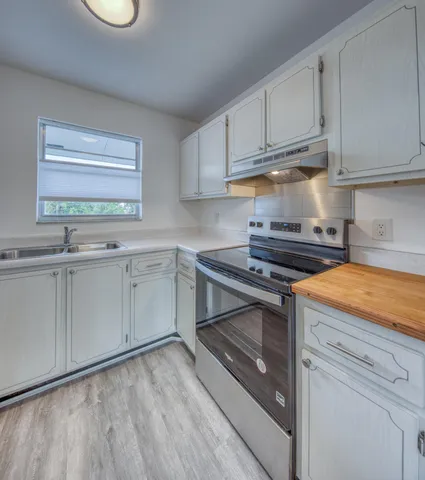 a kitchen with stainless steel appliances granite countertop a sink stove and cabinets