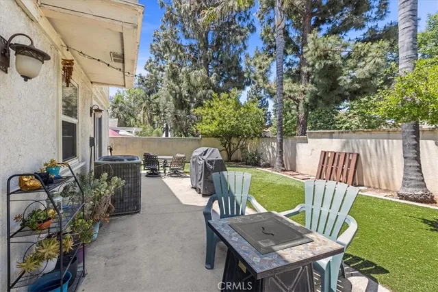 a view of a patio with a table chairs and a swimming pool