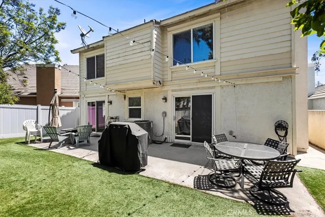 a view of a patio with table and chairs and a barbeque