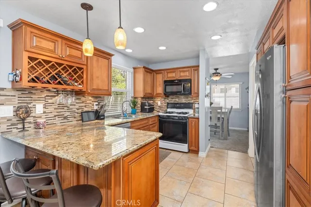 a kitchen with stainless steel appliances granite countertop a stove refrigerator sink and cabinets