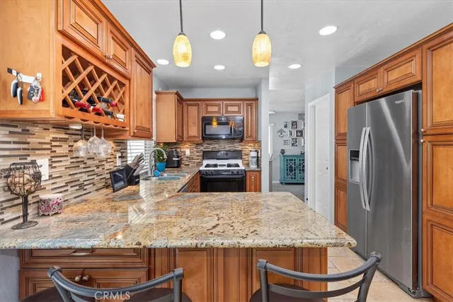 a kitchen with stainless steel appliances granite countertop a stove a refrigerator and a microwave