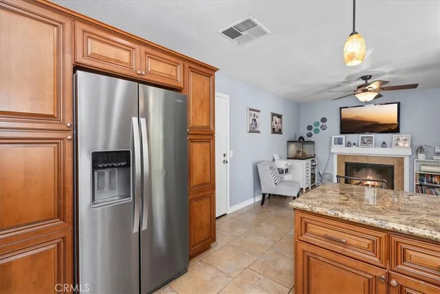 a kitchen with furniture a refrigerator and a fireplace