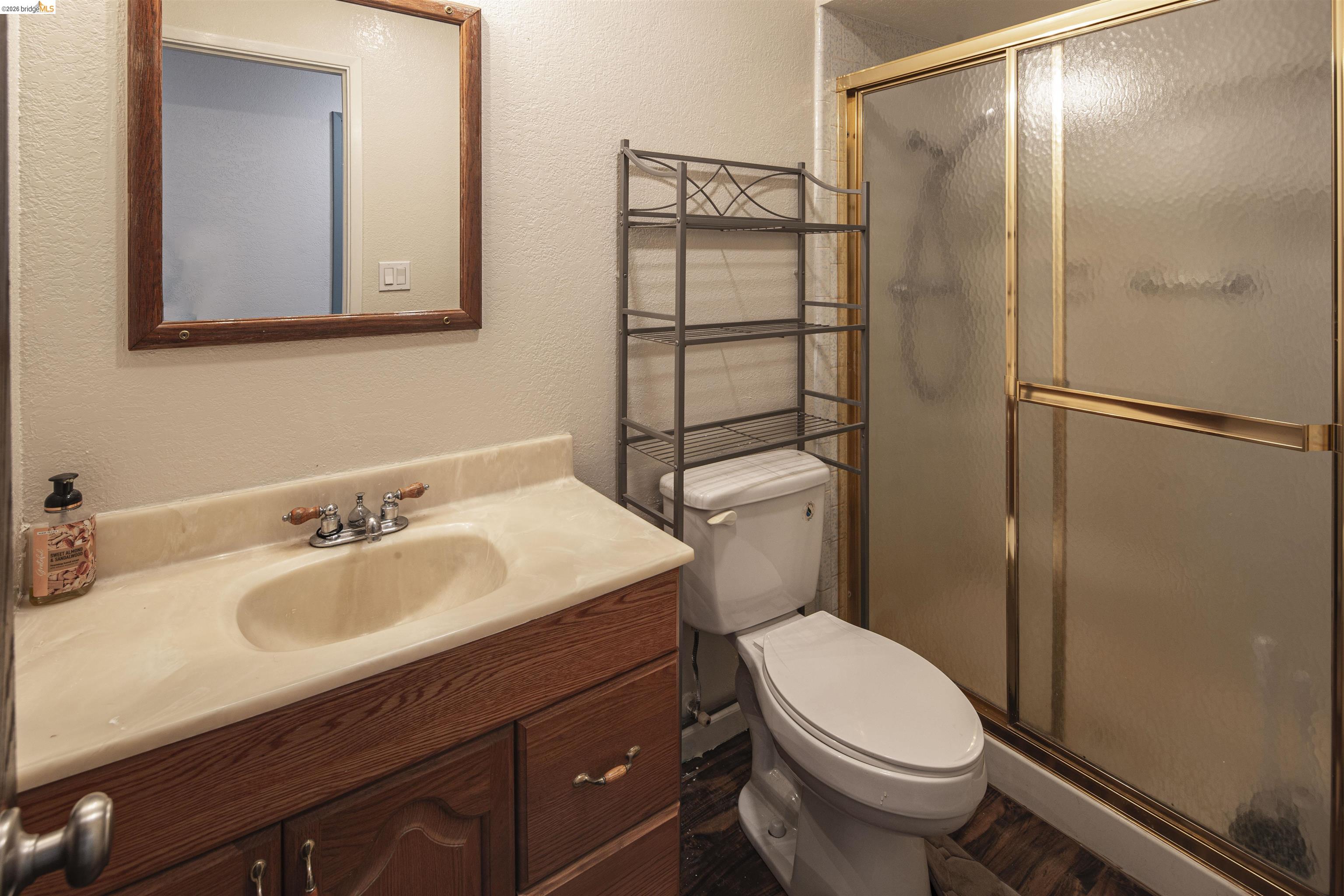 10458 Southworth Road Valley Springs, CA 95252 - Photo 16 of 22 Bathroom with a textured wall, vanity, and a shower stall