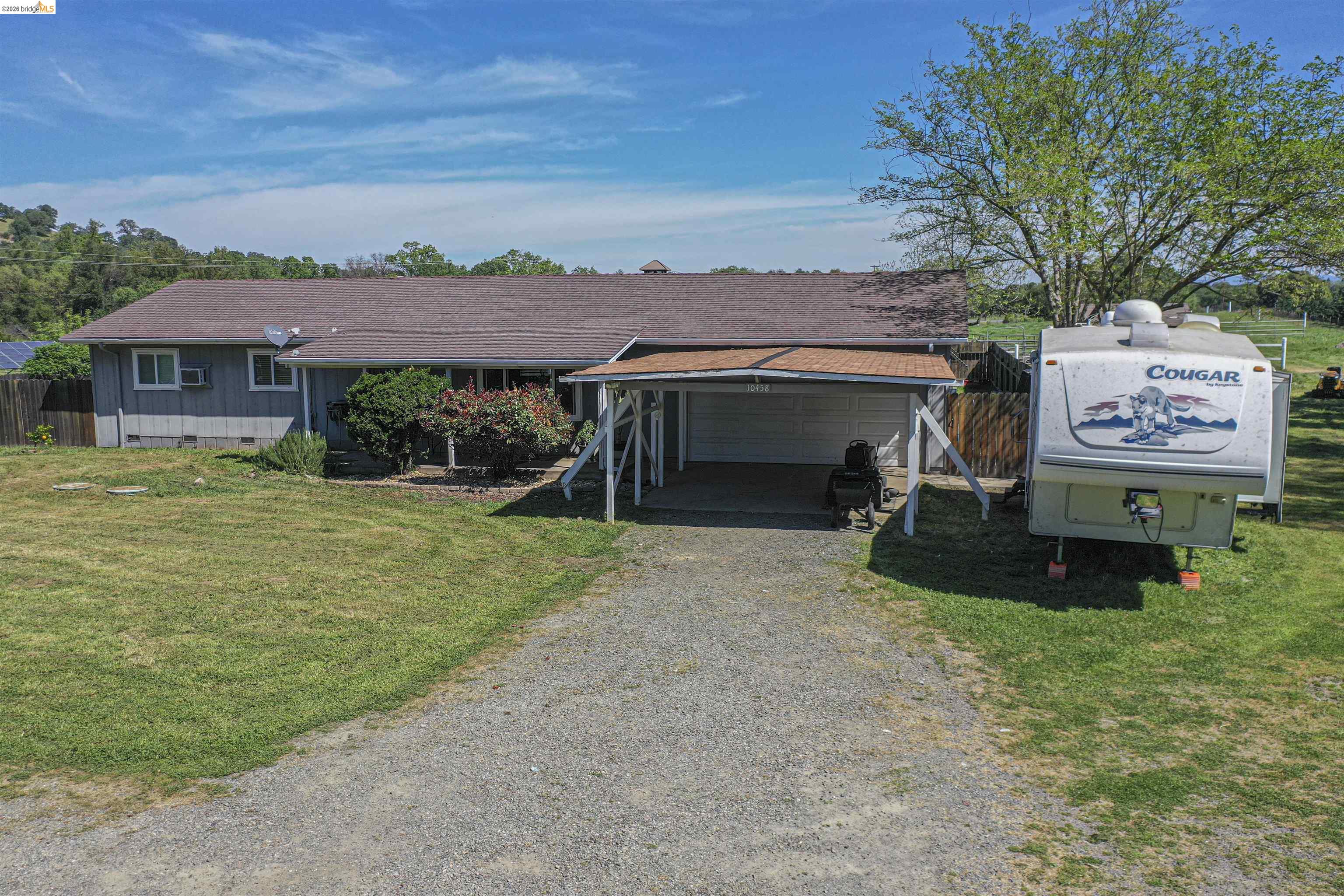 10458 Southworth Road Valley Springs, CA 95252 - Photo 22 of 22 Ranch-style home with gravel driveway, crawl space, a garage, and a carport