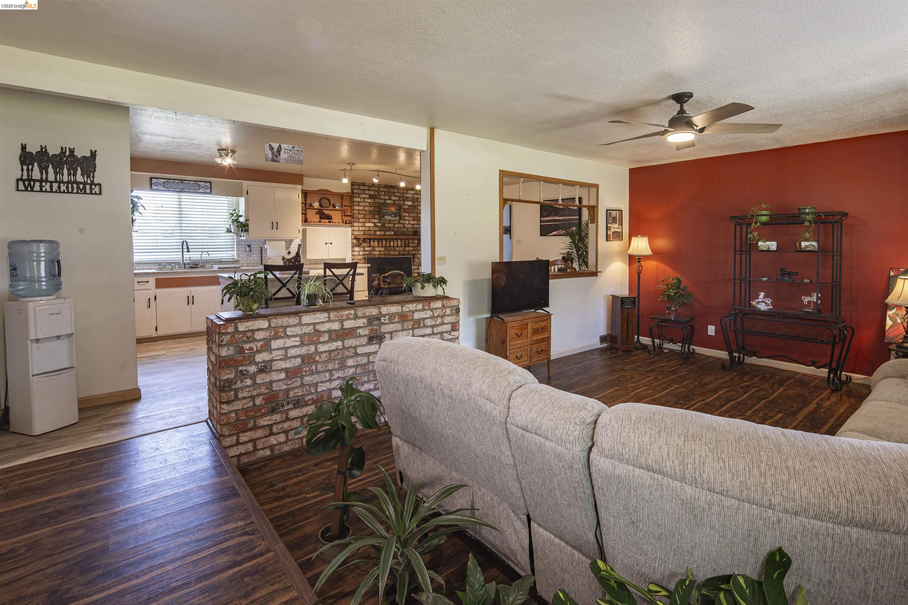 10458 Southworth Road Valley Springs, CA 95252 - Photo 7 of 22 Living area with dark wood-style flooring, ceiling fan, and a textured ceiling
