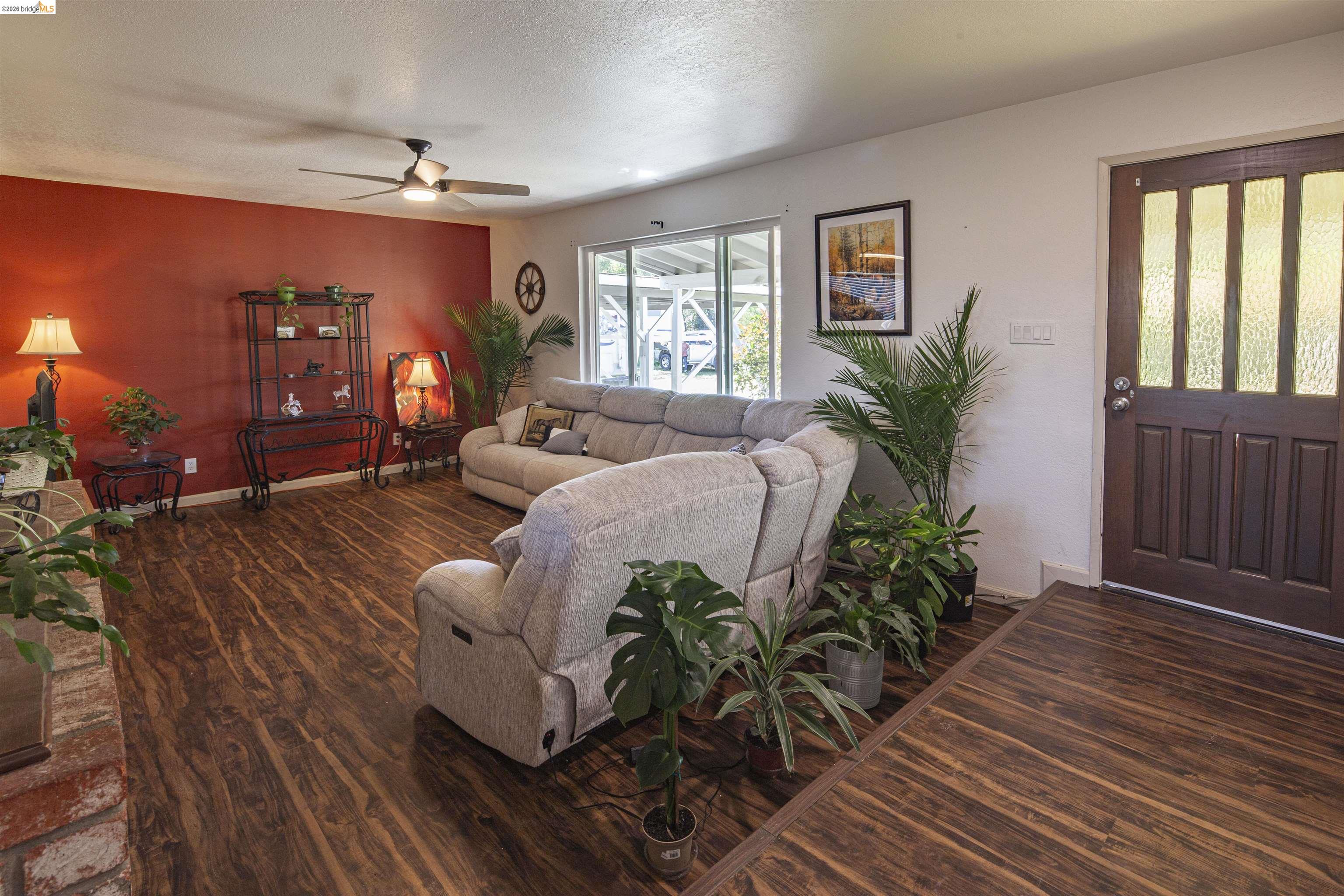 10458 Southworth Road Valley Springs, CA 95252 - Photo 8 of 22 Living room featuring dark wood-style floors, a ceiling fan, and a textured ceiling