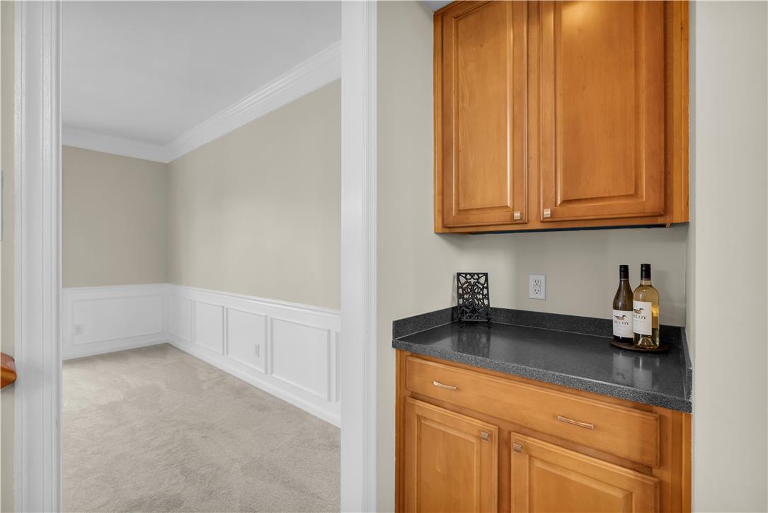 1709 Travers Road Breinigsville, PA 18031 - Photo 18 of 55 A well-appointed wet bar with granite counters services a carpeted room with wainscoting.