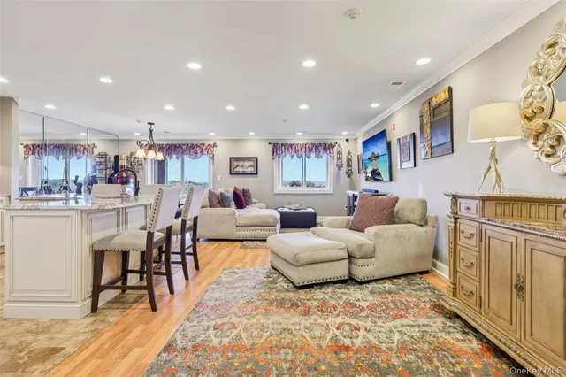 a living room with furniture and a dining table with wooden floor