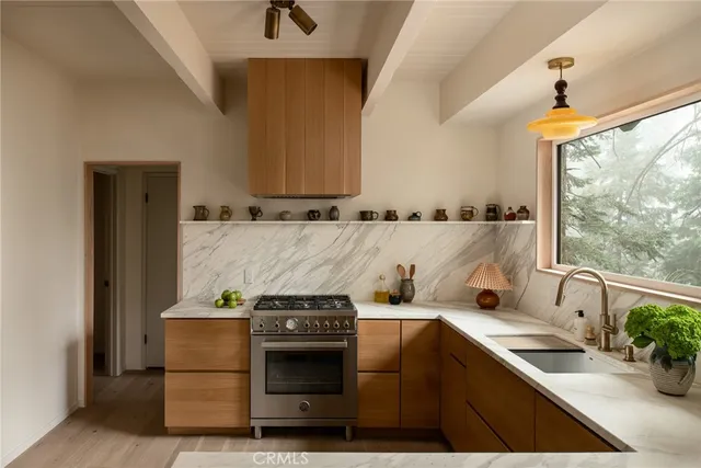 a kitchen with stainless steel appliances granite countertop a sink stove and cabinets