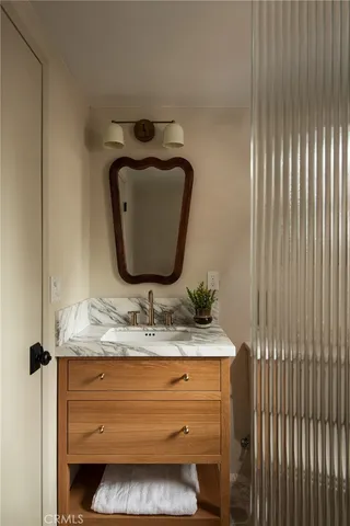 a bathroom with a granite countertop sink and a mirror
