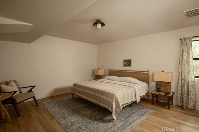 a bedroom with a bed and wooden floor
