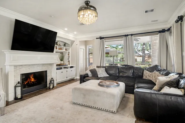 a living room with furniture a flat screen tv and a view of kitchen