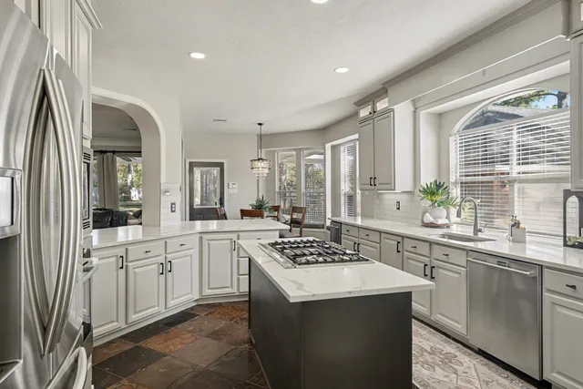 a kitchen with stainless steel appliances granite countertop a sink stove and refrigerator