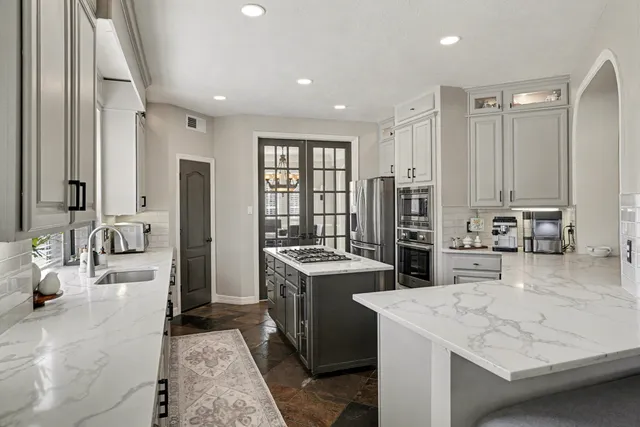 a kitchen with sink stove and refrigerator