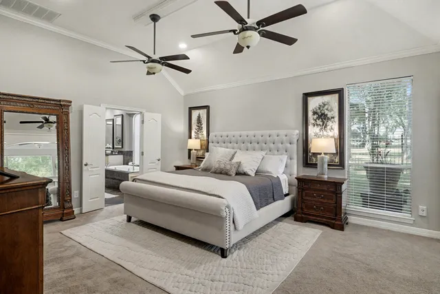 a bedroom with a large bed and a chandelier
