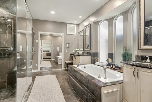 a large spacious bathroom with a double vanity sink a mirror and a bathtub