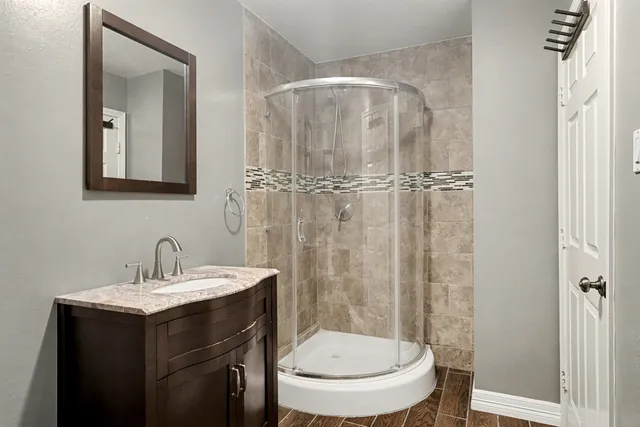 a bathroom with a toilet a sink a mirror a vanity and shower