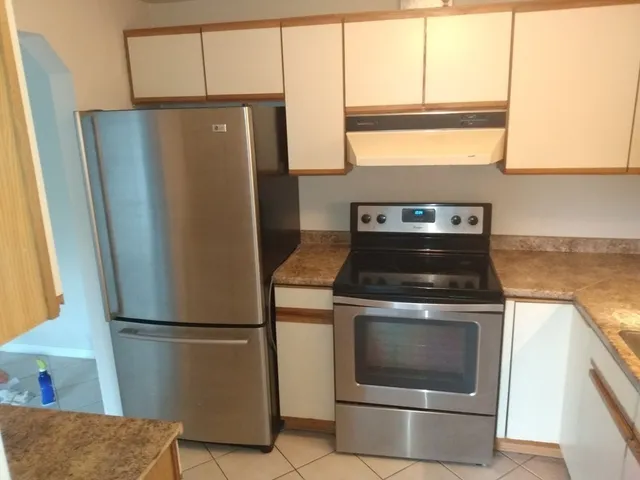 a kitchen with a stove top oven and refrigerator