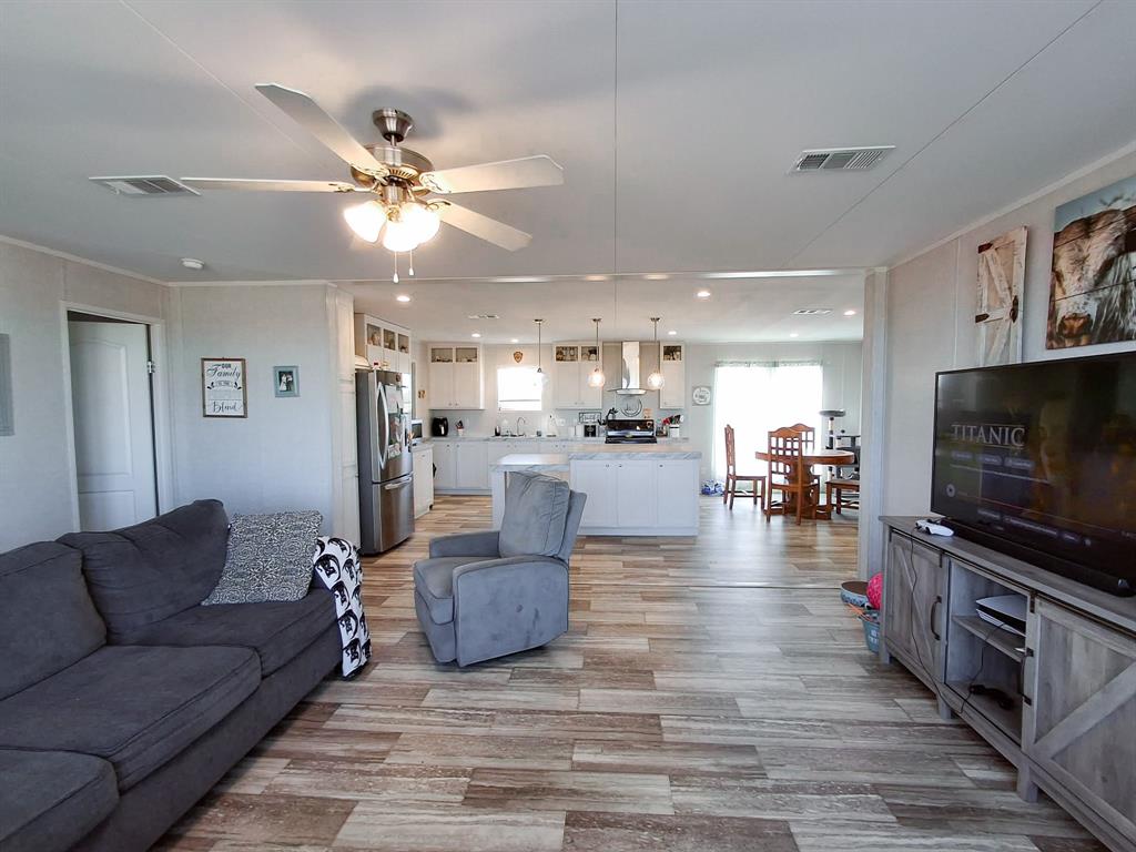 7256 Johnson Road Granbury, TX 76049 - Photo 14 of 40 Living room with light wood-style floors, a ceiling fan, and ornamental molding