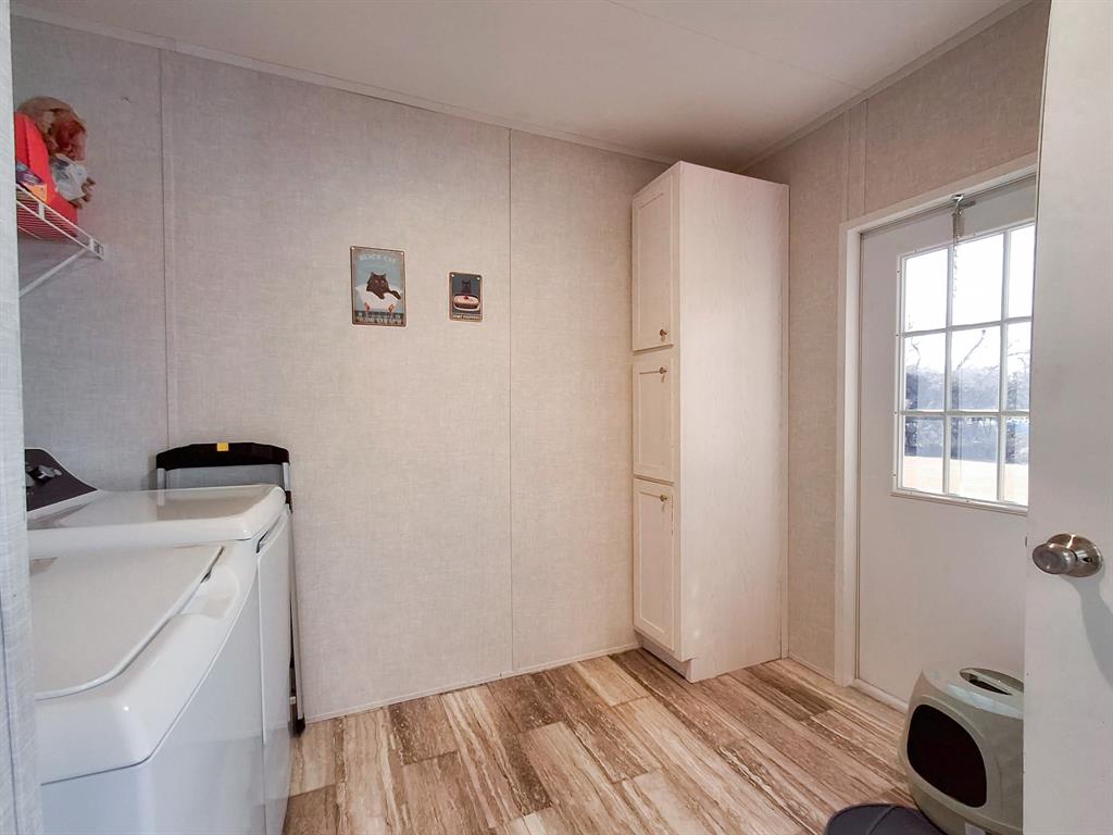 7256 Johnson Road Granbury, TX 76049 - Photo 23 of 40 Laundry room with light wood finished floors and washing machine and clothes dryer