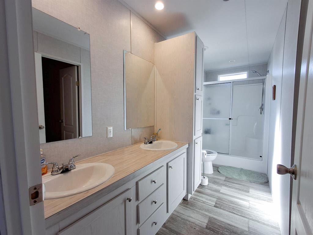 7256 Johnson Road Granbury, TX 76049 - Photo 27 of 40 Full bathroom with double vanity, an enclosed shower, light wood-type flooring, and recessed lighting