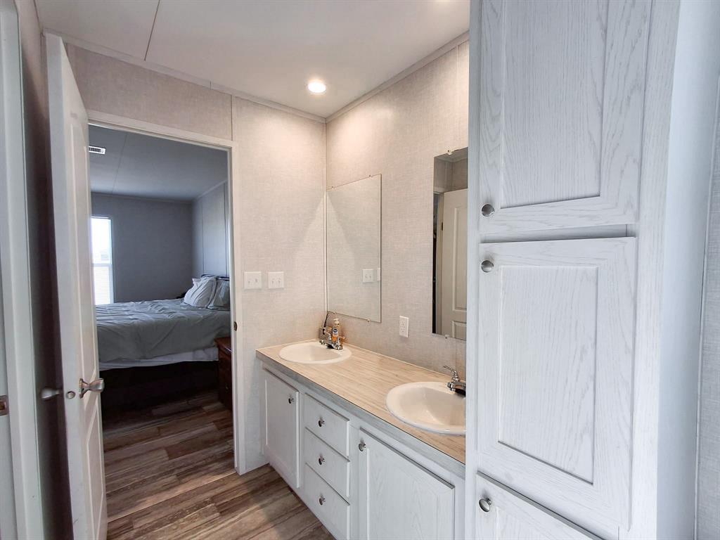 7256 Johnson Road Granbury, TX 76049 - Photo 28 of 40 Ensuite bathroom with double vanity and wood finished floors