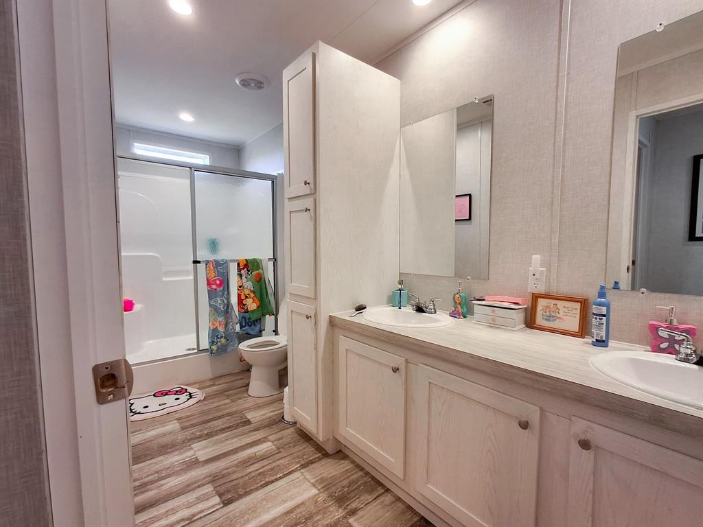 7256 Johnson Road Granbury, TX 76049 - Photo 32 of 40 Full bathroom with double vanity, light wood finished floors, recessed lighting, and bath / shower combo with glass door