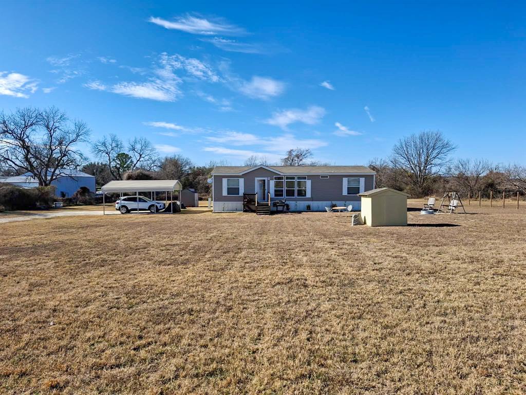 7256 Johnson Road Granbury, TX 76049 - Photo 7 of 40 View of front of property with a front yard, a storage unit, and entry steps