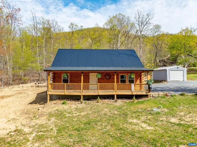 a view of a house with a yard and sitting area