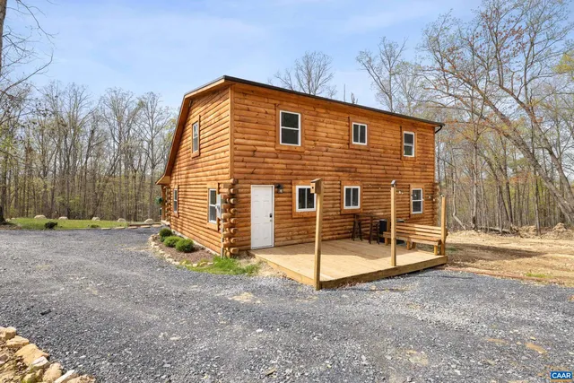 a living room with couches chairs and a stove with wooden floor