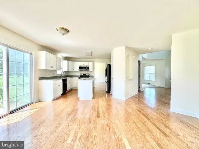 a large kitchen with cabinets and wooden floor