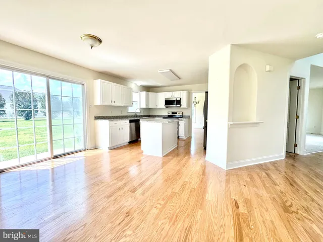 a view of a kitchen with wooden floor and a kitchen