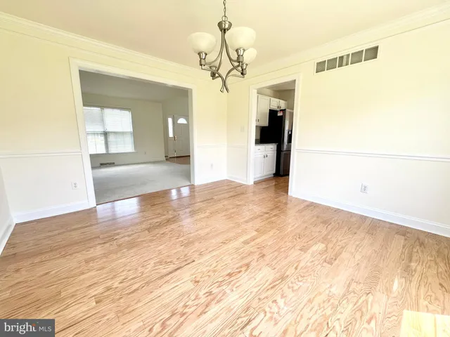 a view of a big room with wooden floor and chandelier