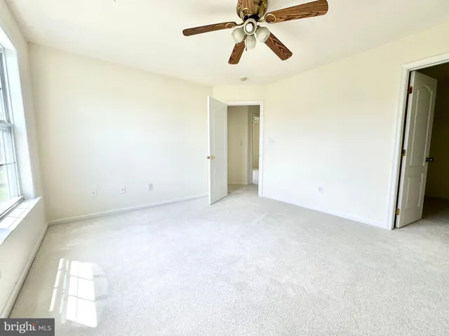 a view of a room with a ceiling fan and a window