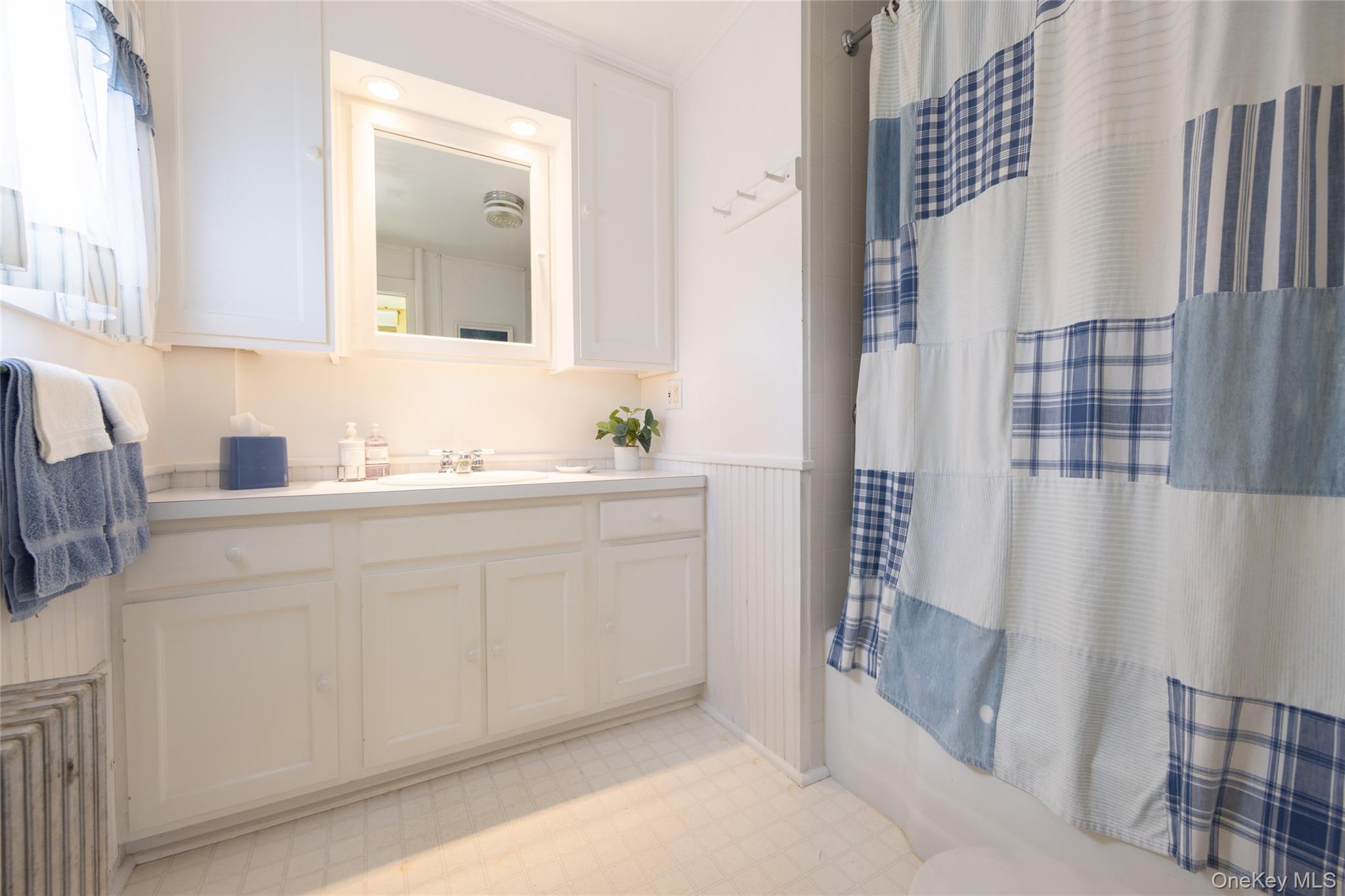 49 Crumley Van Vactor Road Ferndale, NY 12734 - Photo 38 of 50 Bathroom featuring vanity, tile patterned floors, a wainscoted wall, shower / bath combo, and toilet