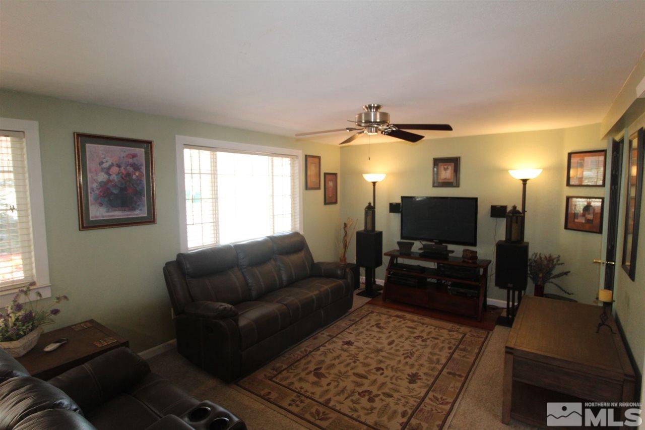 8715 Aquifer Way Reno, NV 89506 - Photo 3 of 18 a living room with furniture and a flat screen tv