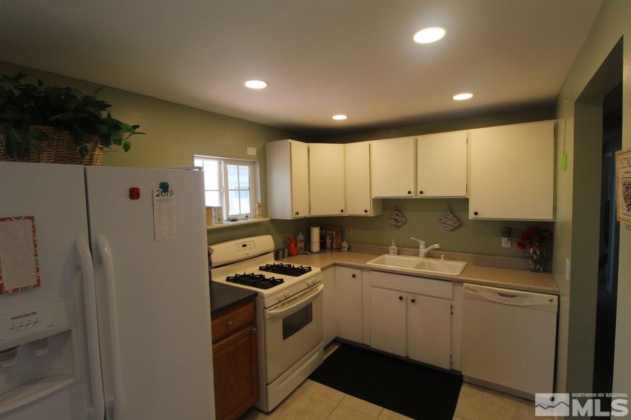 8715 Aquifer Way Reno, NV 89506 - Photo 5 of 18 a kitchen with a sink a refrigerator and cabinets