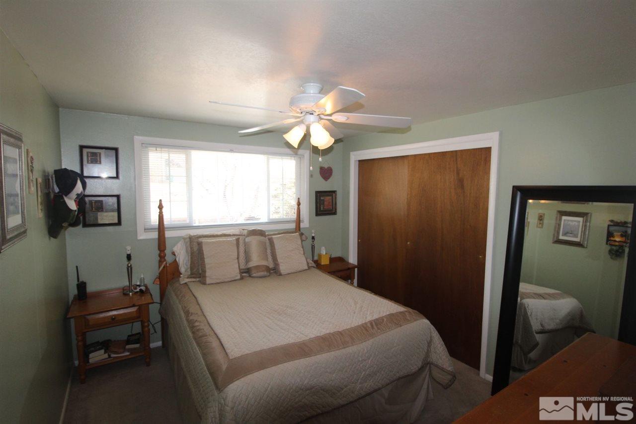 8715 Aquifer Way Reno, NV 89506 - Photo 9 of 18 a bedroom with a bed and a chandelier