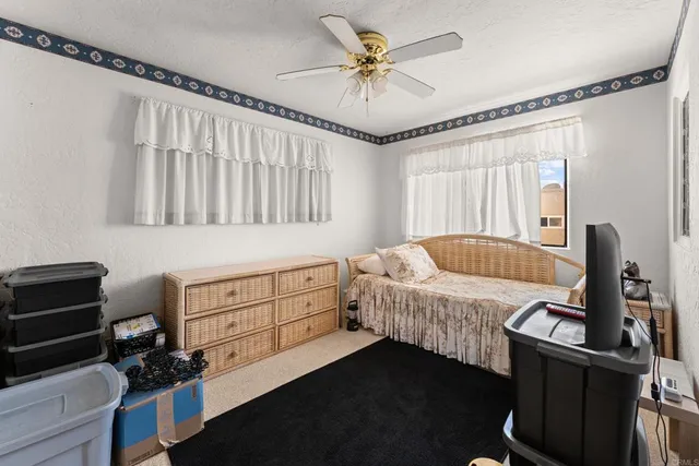 a bedroom with a bed a window and dresser