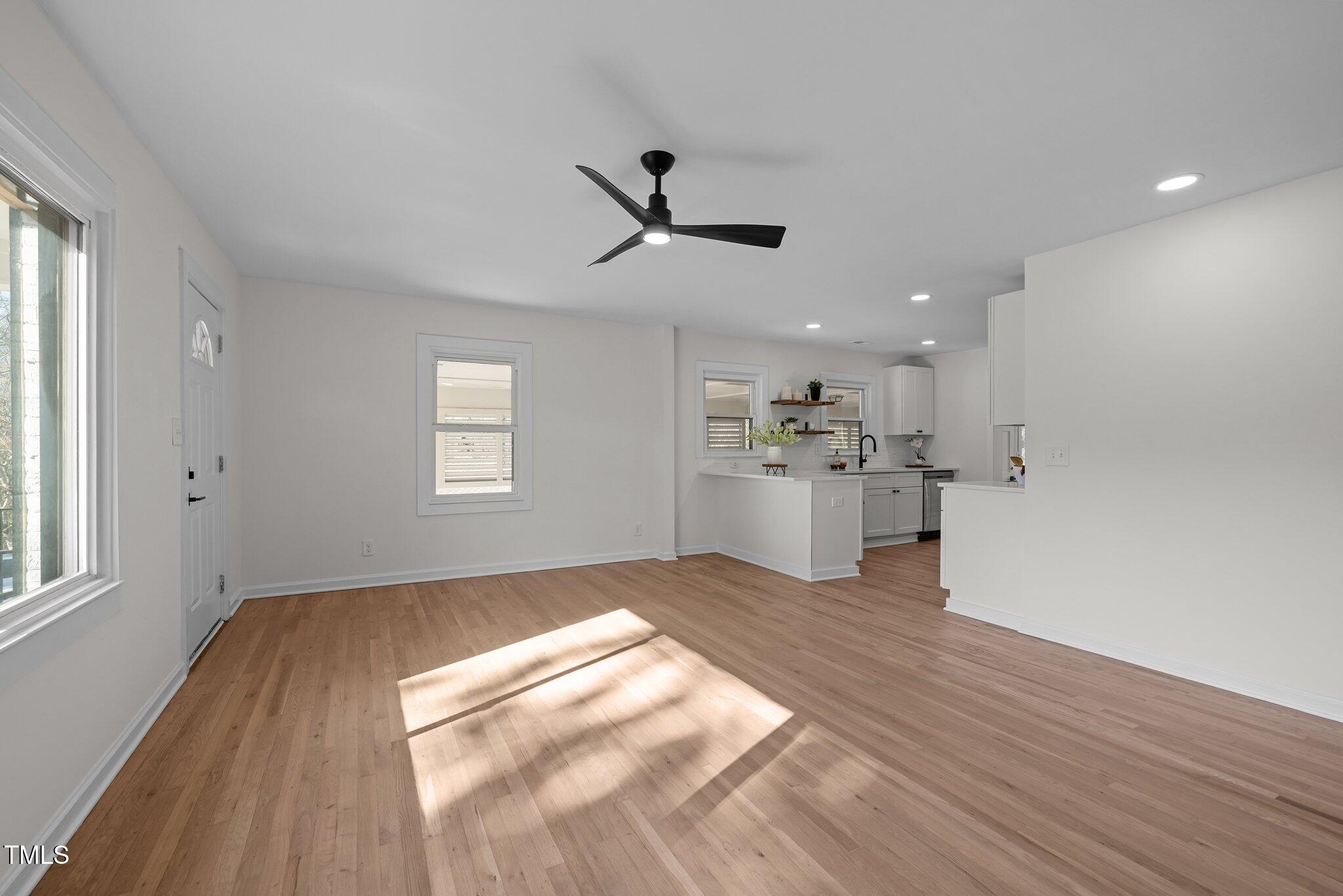 1805 Pritchard Place Durham, NC 27707 - Photo 10 of 46 a view of kitchen and empty room with wooden floor and windows