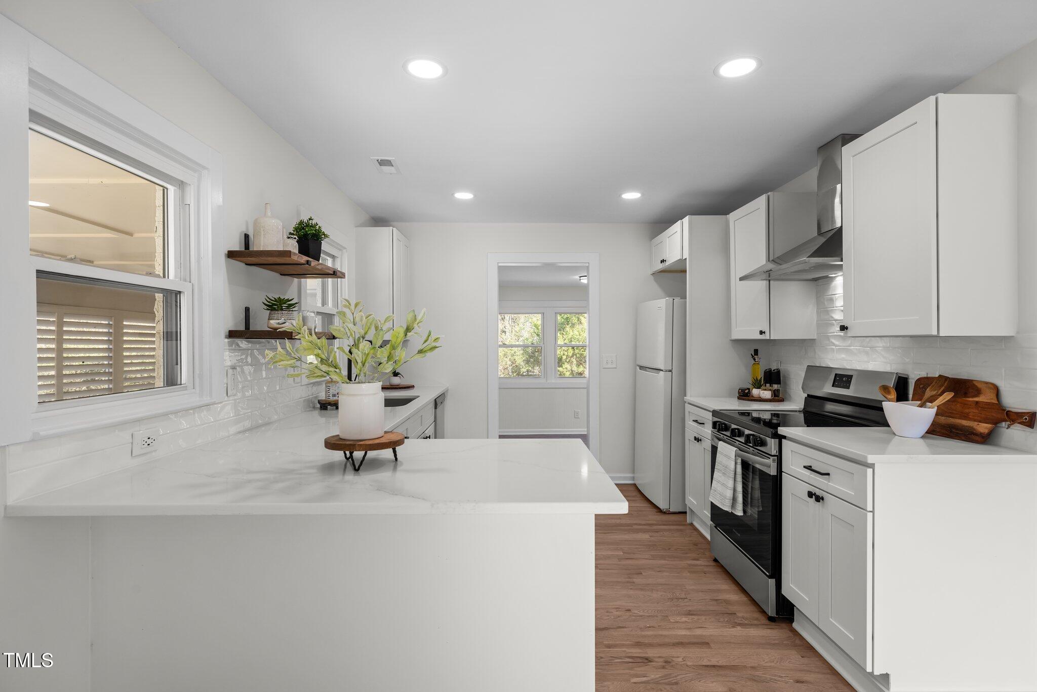 1805 Pritchard Place Durham, NC 27707 - Photo 13 of 46 a kitchen with stainless steel appliances kitchen island granite countertop a sink a stove a refrigerator and cabinets