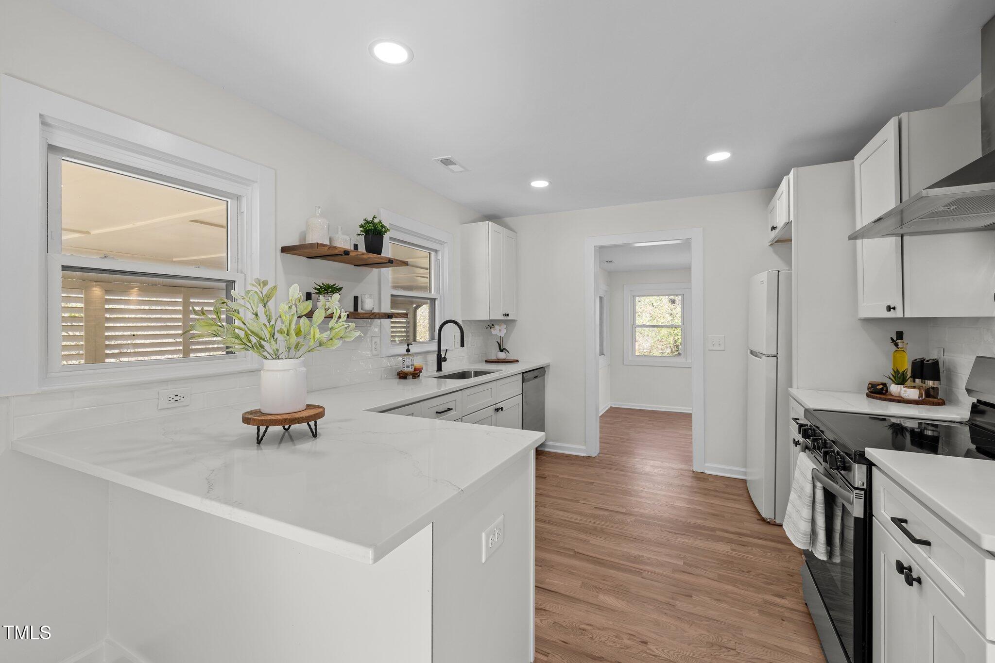 1805 Pritchard Place Durham, NC 27707 - Photo 14 of 46 a view of kitchen with kitchen island a sink wooden floor and living room view