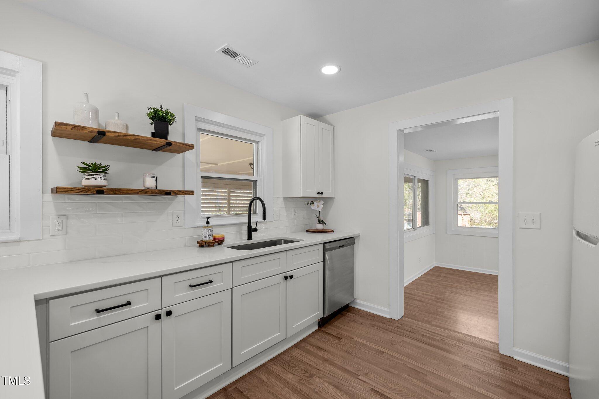 1805 Pritchard Place Durham, NC 27707 - Photo 15 of 46 a kitchen with stainless steel appliances white cabinets and wooden floor