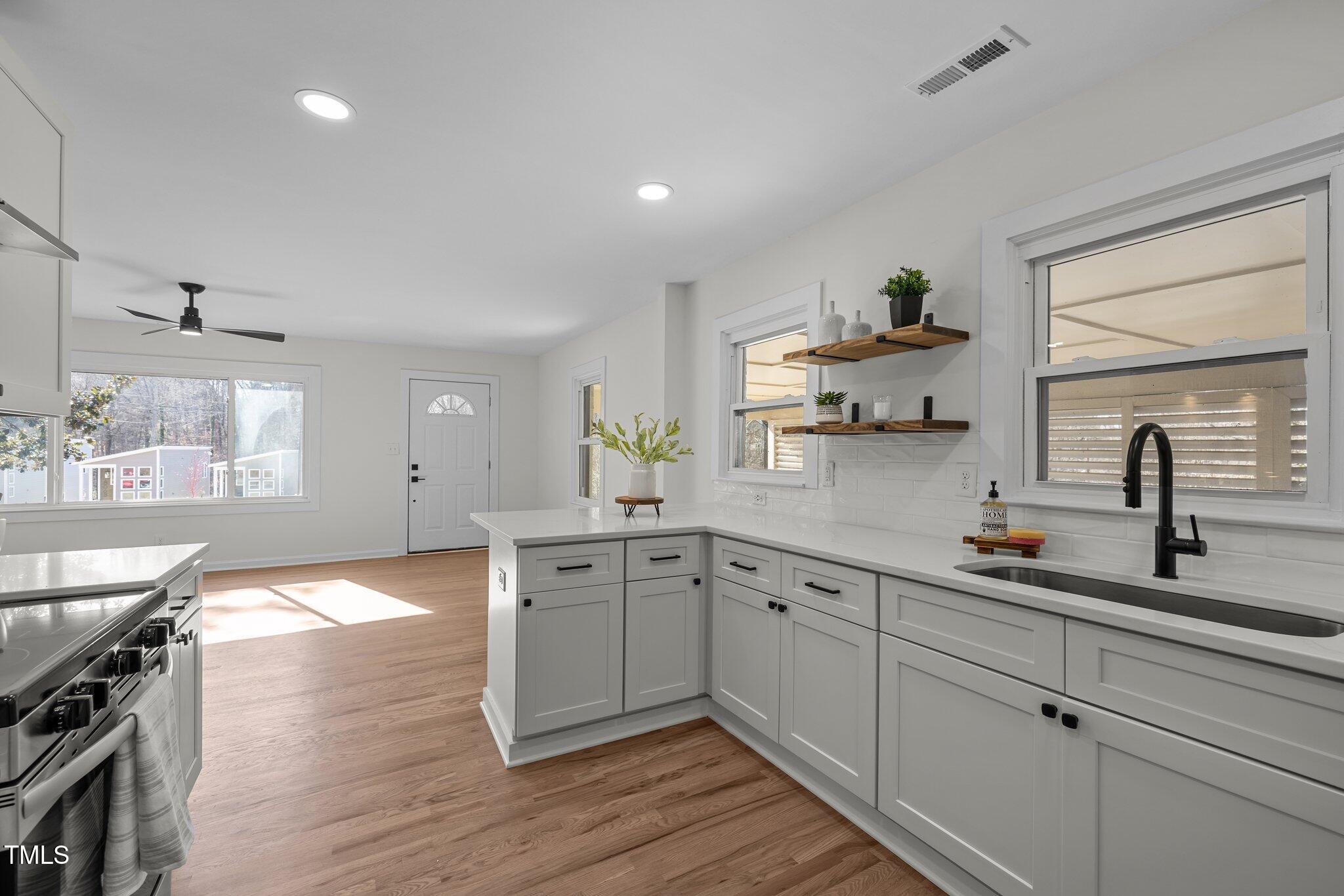 1805 Pritchard Place Durham, NC 27707 - Photo 16 of 46 a kitchen with sink cabinets and wooden floor