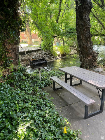 1175 Canyon Road, Unit A 5 Ogden, UT 84404 - Photo 3 of 15 Outdoor patio area featuring a picnic table with seating, an adjacent charcoal grill, and a natural water feature
