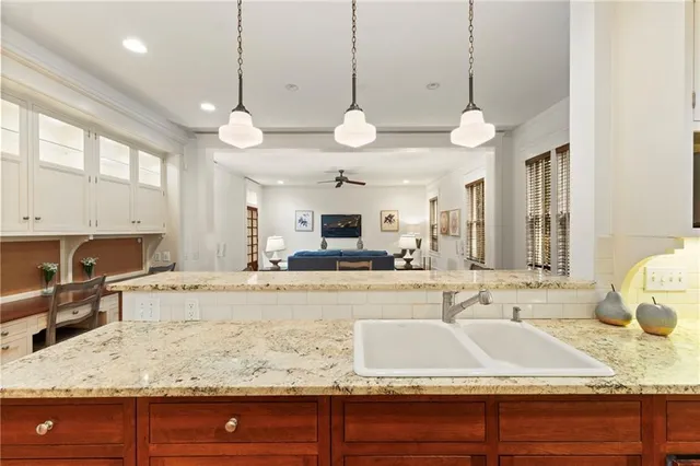 a large kitchen with kitchen island a stove a sink a center island and living room view