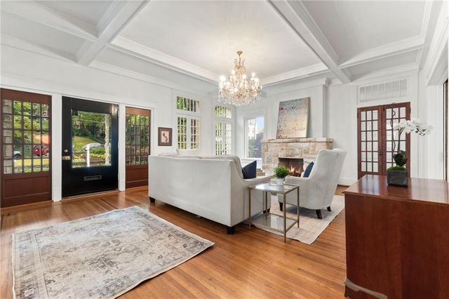 a living room with fireplace furniture and a chandelier