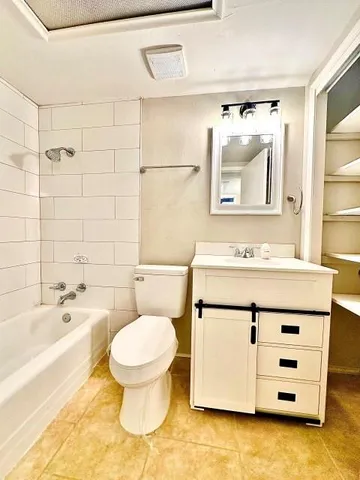 a spacious bathroom with a granite countertop sink mirror vanity and a bathtub